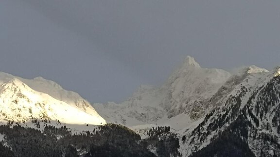 A majestic mountain panorama with snow-covered peaks. The clouds create a dramatic interplay of light. - Haus Evi - Oetz