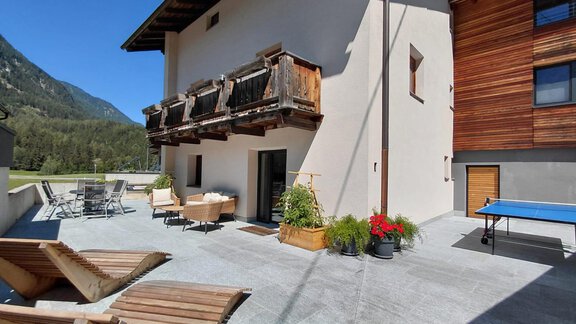 A comfortable terrace with modern furniture and a view of the mountains. The sun is shining and the atmosphere is inviting. - Haus Gstrein - Oetz