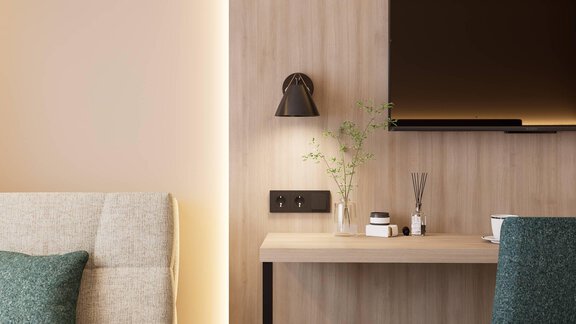 Ein modern eingerichteter Raum mit Holzverkleidung und weichen Farben. Ein kleiner Tisch mit Dekoration und eine Wandlampe schaffen eine gemütliche Atmosphäre. - Hotel Marko - Oetz