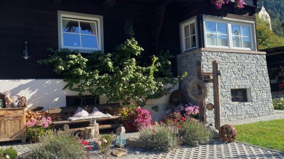 A traditional cottage with colorful flowers on the facade. The front yard is well-maintained and invites you to linger. - Landhaus Edelweiss - Oetz