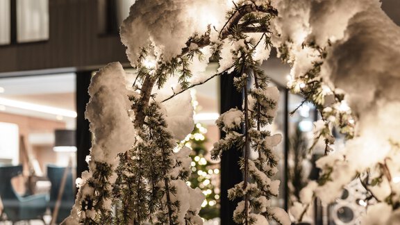 Ein verschneiter Garten mit einem schön dekorierten Tor. Im Hintergrund ist ein warm beleuchtetes Wohnzimmer zu sehen. - MYALPS Tirol - Oetz