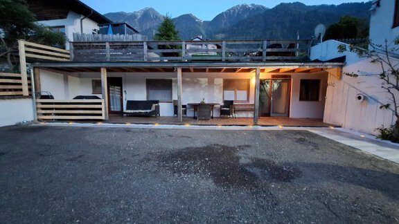 A covered area with furniture and a table. In the background, mountains and a tranquil atmosphere can be seen. - Appartement Harmony - Sautens