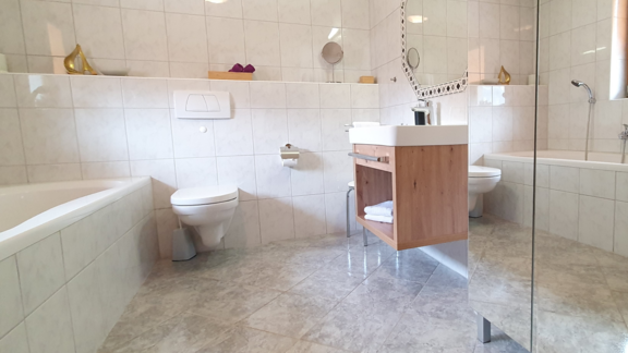 First bathroom with bathtub, WC, washbasin - Ferienwohnung "Zum Glück" - Sautens