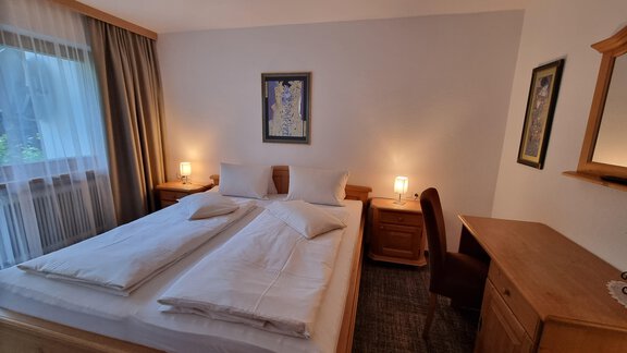 Ein gemütliches Schlafzimmer mit einem Doppelbett, sanfter Beleuchtung. Die Bilder von Klimt geben dem Zimmer seinen Namen. - Haus Alpenglühn - Sautens