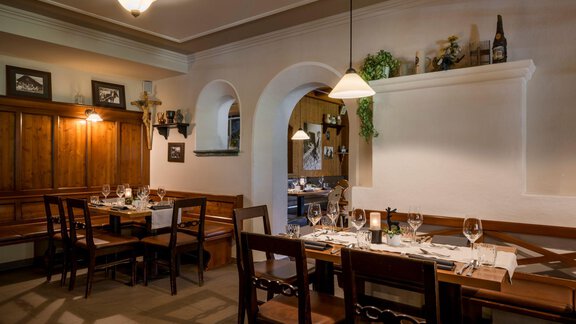 Ein gemütliches Restaurant mit Holzmöbeln und elegant eingedeckten Tischen. Die warmen Farben und die stilvolle Beleuchtung schaffen eine einladende Atmosphäre. - Alpengasthof Grüner - Sölden
