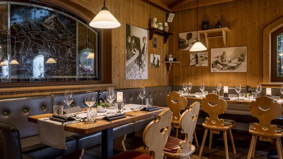 Ein gemütliches Restaurant mit holzverkleideten Wänden und einer einladenden Atmosphäre. Die Tische sind elegant gedeckt und dekoriert. - Alpengasthof Grüner - Sölden