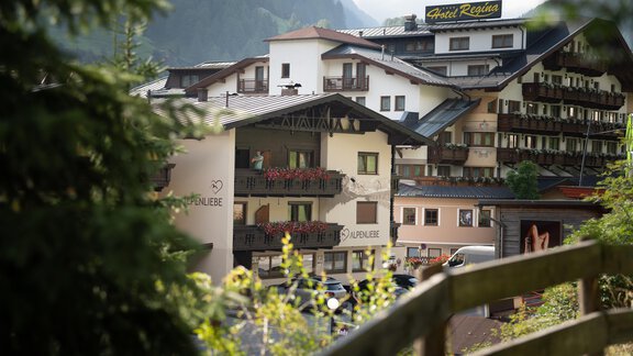 A picturesque hotel building in the mountains, surrounded by trees. The property offers an inviting atmosphere with several balconies. - Alpenliebe - Sölden