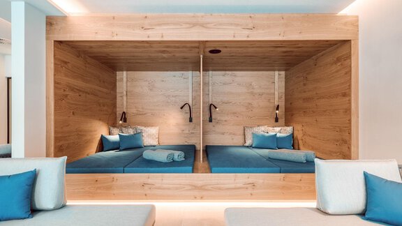 A modern bedroom with forward-thinking design. It features two cozy beds in a wooden frame and blue pillows. - AlpenParks The Secret Sölden - Sölden