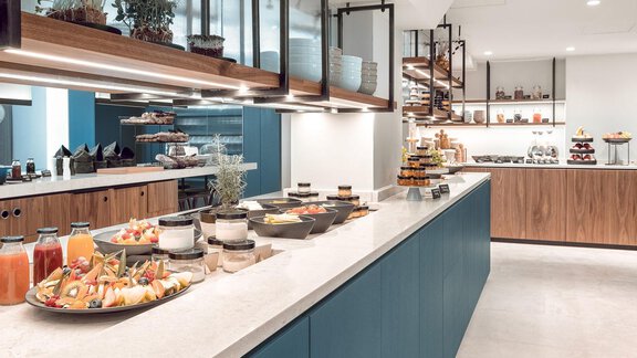 An elegant restaurant with a modern buffet. Various dishes and drinks are beautifully arranged on the table. - AlpenParks The Secret Sölden - Sölden