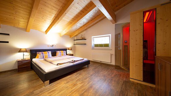 A modern bedroom with a wooden ceiling and tasteful decor. The room features a double bed and a pleasant atmosphere. - Alpensweet - Sölden