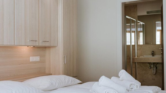 A modern bedroom with a double bed and fresh towels. The room has bright furniture and a pleasant lighting. - Appartement Bergbach Sölden - Sölden