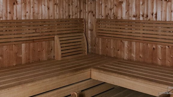 A cozy sauna with a wooden bench and wooden paneling. - Appartement Bergbach Sölden - Sölden