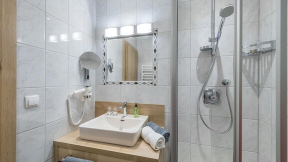 A modern bathroom with a shower and a wooden sink. Bright tiles create a friendly atmosphere. - Appartement Cristallo - Sölden