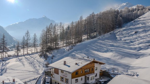 A cozy house in a snowy landscape. In the background, mountains stretch out under a clear blue sky. - Appartement Diamant - Sölden