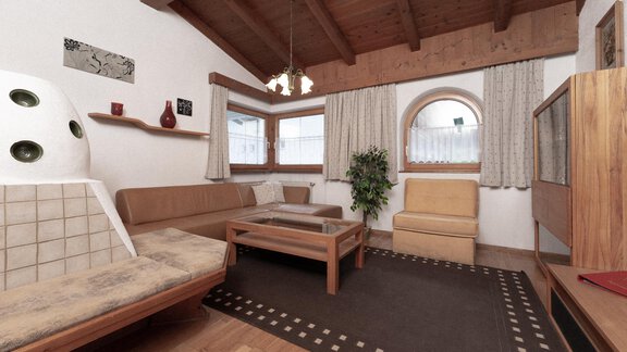 A cozy living room with a wooden ceiling and large windows. There is a seating area and a small table. - Appartement Gehörde Sölden - Sölden