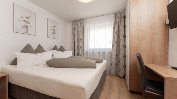 A comfortable hotel room with a double bed and a desk. Large windows provide plenty of daylight and a pleasant atmosphere. - Appartement Gehörde Sölden - Sölden