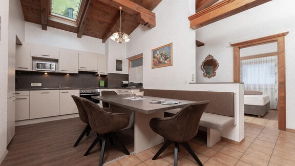 A modern kitchen with a dining table and cozy chairs. Bright walls and wooden details give the space a warm atmosphere. - Appartement Gehörde Sölden - Sölden