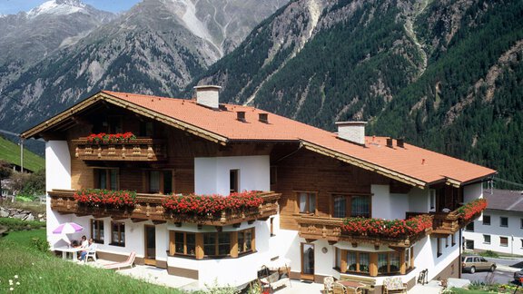 A cozy alpine house with flower boxes and wooden cladding. Majestic mountains can be seen in the background. - Appartement Rangger - Sölden