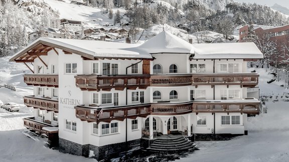 An elegant hotel amidst a snowy landscape. Surrounded by mountains, it radiates a serene winter atmosphere. - Appartementhaus Kathrin - Sölden