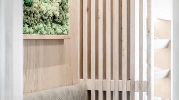 A modern room with wooden paneling and a well-maintained moss picture. A cozy seating area with a cushion complements the clear design. - Appartementhaus Kathrin - Sölden
