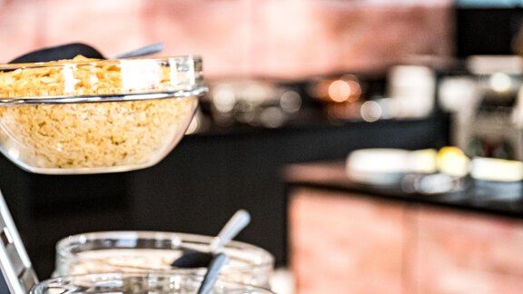 Ein stilvolles Buffet mit Glasbehältern voller Müsli und Haferflocken. Im Hintergrund sind modern gestaltete Küchenmöbel zu sehen. - Bäckelar Wirt - Sölden