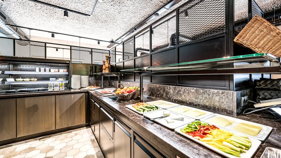 Eine moderne Küche mit einem Buffetbereich. Verschiedene frische Zutaten sind auf dem Tisch angerichtet. - Bäckelar Wirt - Sölden