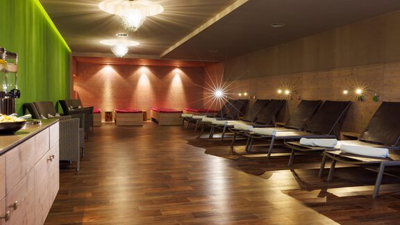 Ein entspannender Wellnessbereich mit Liegen und sanfter Beleuchtung. Die Wand ist in beruhigenden Farben gehalten und es gibt eine entspannte Atmosphäre. - Bäckelar Wirt - Sölden