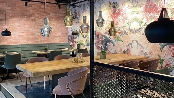 Ein modernes Restaurant mit stilvollen Möbeln und einer bunten Wandgestaltung. Die Beleuchtung ist elegant und schafft eine einladende Atmosphäre. - Bäckelar Wirt - Sölden