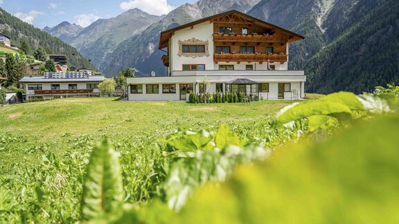 A beautiful chalet amidst green meadows and mountains. The sky is clear and the surroundings seem inviting and peaceful. - Belmonte Sölden - Sölden