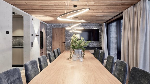 A modern meeting room with a long wooden table and stylish chairs. The walls are decorated with wood and stone, and there is soft lighting from elegant lamps. - Chalet White Pearl by MYALPS - Sölden