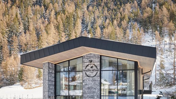 A modern, architecturally appealing house in a snow-covered landscape. The surroundings are surrounded by snow-covered mountains and trees. - Chalet White Pearl by MYALPS - Sölden