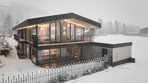 A modern house in the snow with large windows and a balcony. The winter landscape is covered with fresh snow. - Chalet White Pearl by MYALPS - Sölden