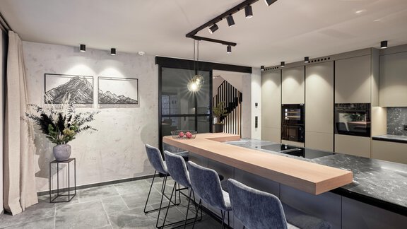 Modern kitchen with a long table and stylish chairs. Bright walls and minimalist decor create an inviting atmosphere. - Chalet White Pearl by MYALPS - Sölden