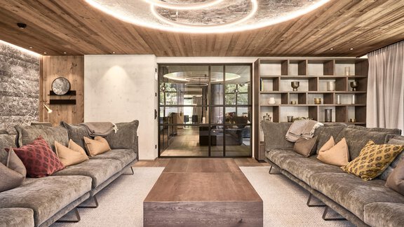 A modern living room with cozy sofas and colorful cushions. The ceiling has stylish lighting, and the room feels welcoming and bright. - Chalet White Pearl by MYALPS - Sölden
