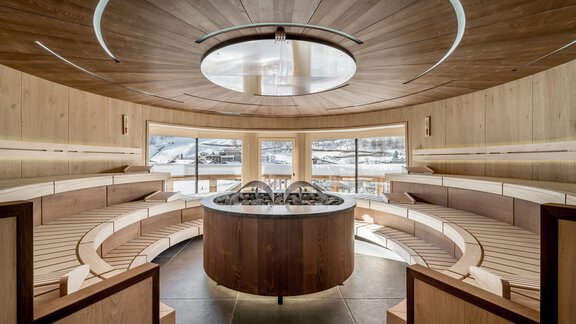 Ein modernes Spa mit eleganten Holzelementen und einer runden Sitzanordnung. Große Fenster bieten einen Blick auf die Umgebung. - Das Central - Alpine . Luxury . Life - Sölden