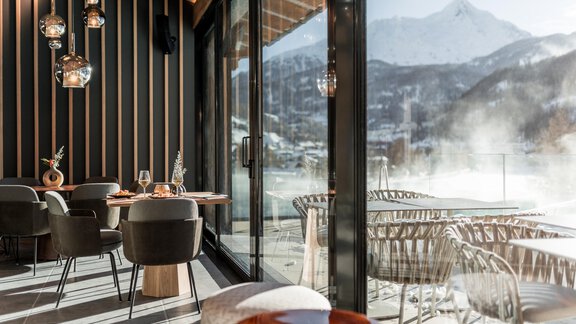 Ein modernes Restaurant mit großen Fenstern und Blick auf die schneebedeckten Berge. Die eleganten Möbel und die gemütliche Atmosphäre laden zum Verweilen ein. - Das Central - Alpine . Luxury . Life - Sölden