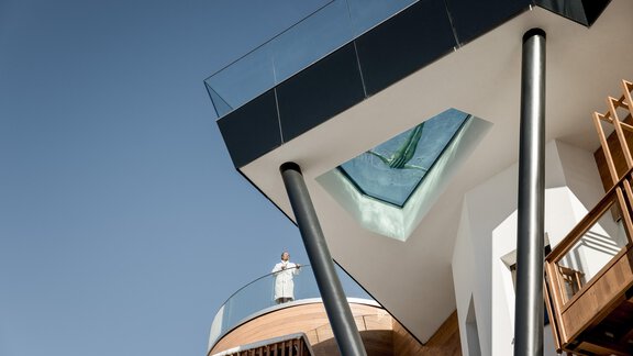 Ein modernes Gebäude mit einem rechteckigen Obergeschoss und einem Glasdach. Die Architektur ist minimalistisch und reflektiert einen klaren blauen Himmel. - Das Central - Alpine . Luxury . Life - Sölden