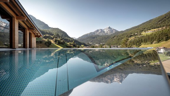 Ein Infinity-Pool mit Blick auf die majestätischen Berge. Die klare Wasseroberfläche spiegelt die umliegende Landschaft wider. - Das Central - Alpine . Luxury . Life - Sölden