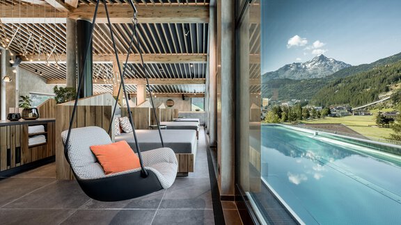 Ein modernes Spa mit einem schwingenden Sessel und einem Blick auf die Berge. Der Infinity-Pool erweitert sich bis zum Horizont. - Das Central - Alpine . Luxury . Life - Sölden