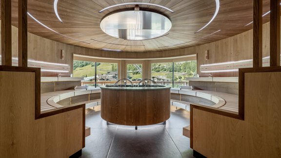 Ein modernes Spa mit runder Holzverkleidung und großen Fenstern. Der zentrale Bereich bietet einen ruhigen Aussichtspunkt ins Freie. - Das Central - Alpine . Luxury . Life - Sölden