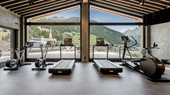 Ein modernes Fitnessstudio mit Blick auf die Berge. Mehrere Trainingsgeräte stehen bereit, um ein effektives Workout zu ermöglichen. - Das Central - Alpine . Luxury . Life - Sölden
