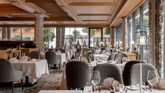 Ein elegantes Restaurant mit stilvoll gedeckten Tischen und gemütlicher Atmosphäre. Große Fenster bieten einen Blick auf die Umgebung. - Das Central - Alpine . Luxury . Life - Sölden