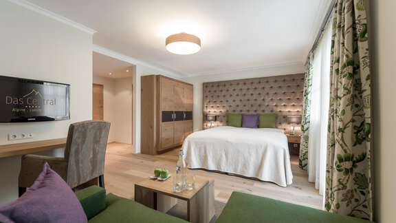 Ein modernes Zimmer mit einem großen Bett und stilvollen Möbeln. Die Inneneinrichtung ist hell und einladend, ideal für entspannte Übernachtungen. - Das Central - Alpine . Luxury . Life - Sölden