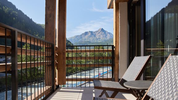 A balcony with two lounge chairs and a view of the mountains. The nature is sunny and inviting, perfect for relaxing. - Edelweiss echt.charmant. - Sölden