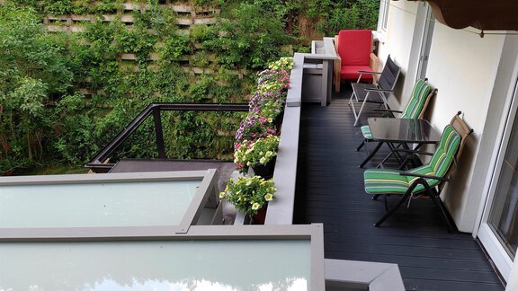 A beautiful balcony with blooming plants and comfortable chairs. In the background, a green wall of plants is visible. - Ferienhaus F2 - Sölden - Sölden