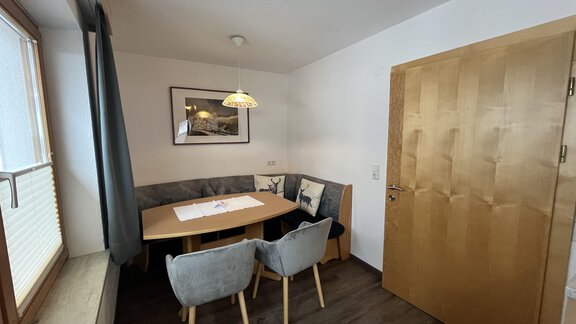 A cozy dining area with a table and elegant chairs. The window lets in plenty of light and creates a pleasant atmosphere. - Franzele Appartements & Zimmer - Sölden