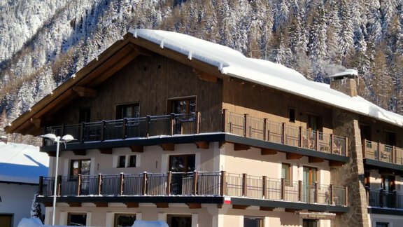A charming, snow-covered house in a wintry landscape. Majestic mountains can be seen in the background. - Gästehaus Dr. Riml - Sölden