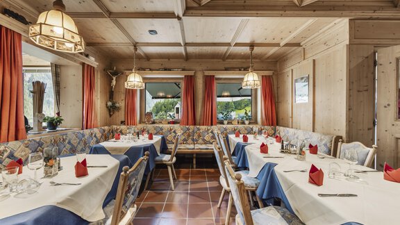 A cozy restaurant with rustic wooden interiors. The tables are elegantly set and offer an inviting atmosphere. - Gasthof Granstein - Sölden