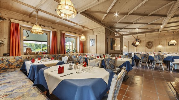 A cozy restaurant with wooden elements and warm colors. The tables are lovingly set, and there is an inviting atmosphere. - Gasthof Granstein - Sölden