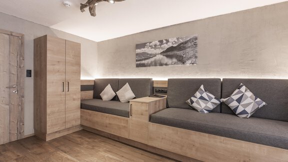 A modern living room with a cozy seating area and cushions. The walls are painted in neutral colors, and there is a nice wooden floor. - Haus Manfred - Sölden